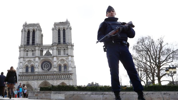 A French police officer stands guard outside Notre Dame cathedral in Paris earlier this year.