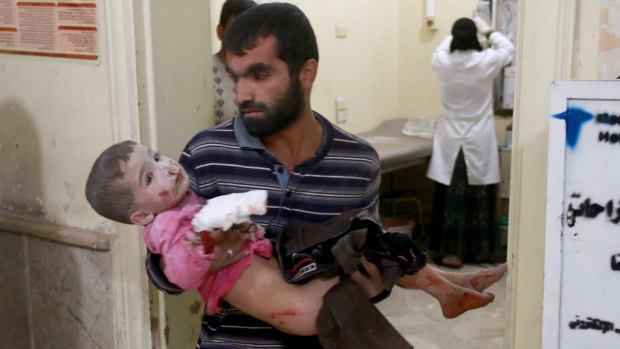 A Syrian man carries his son to a field hospital after the Syrian and Russian armies carried out air strikes in Aleppo.