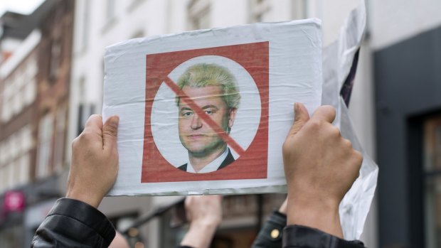 A protester holds a placard depicting Geert Wilders as he campaigns in Heerlen.