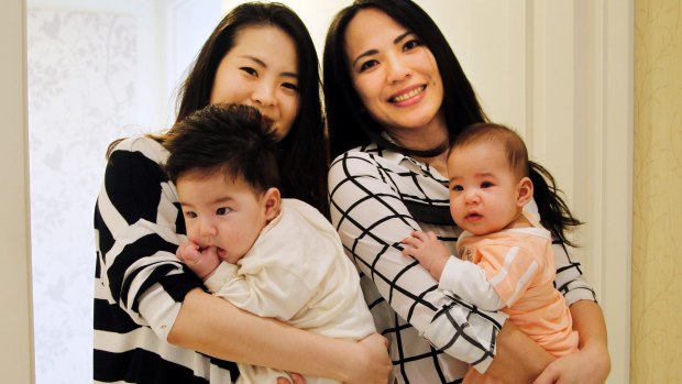 Cindy Su, left, and Lana Yu hold their babies in Taipei, Taiwan.  