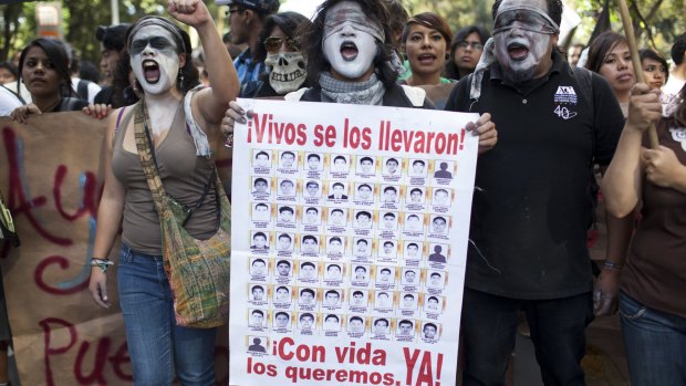Protesters and family of 43 missing students from Guerrero State, in Mexico, march to protest against the government and demand answers about the missing students in November, 2014.
