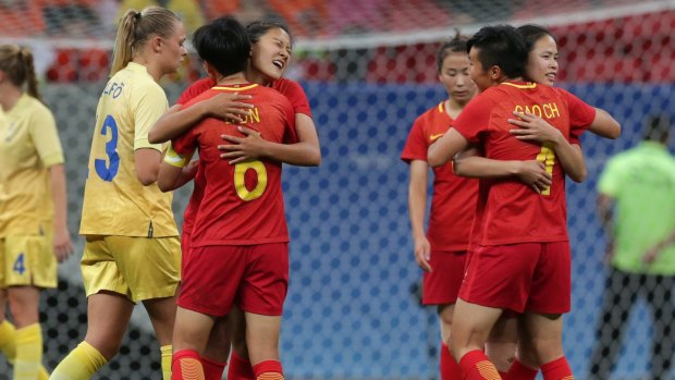 Chinese players hug after a group E match of the women's Olympic football tournament between China and Sweden in Brasilia, Brazil.