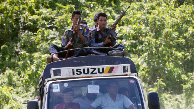 Myanmar police travel on the roof of a truck carrying local UN staff as they flee the violence on August 28.