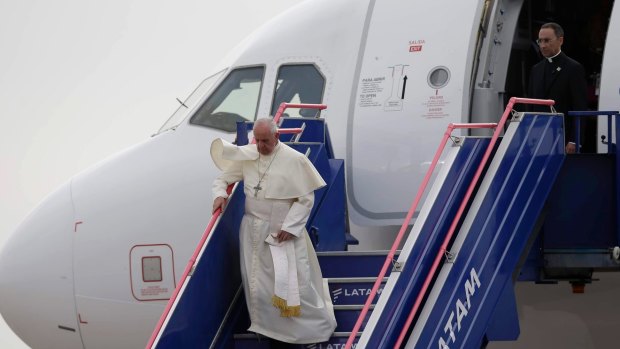 Pope Francis walks down the stairway as he arrives at the international airport in Lima, Peru.