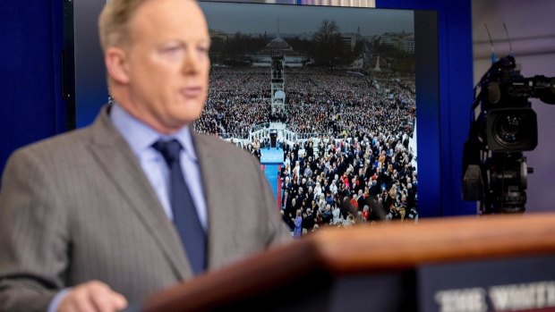An image of the inauguration of President Donald Trump is displayed behind White House press secretary Sean Spicer as he speaks at the White House.