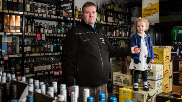 Owner of Urban Cellars Curtin, Paul Cains - with his four-year-old daughter Sophie - fears the stalemate between the owners and residents could kill the local shops.