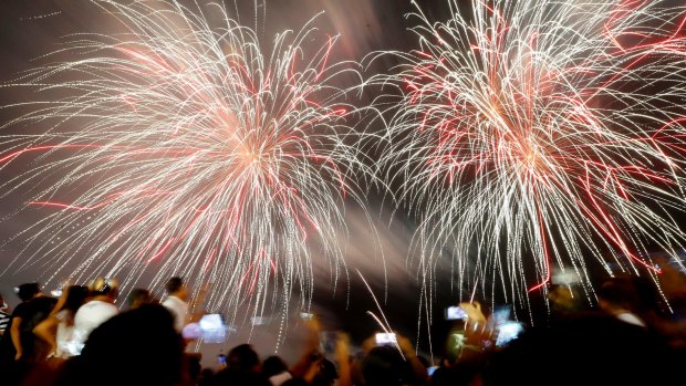 Filipino revelers watch as fireworks light up the sky to welcome the New Year at the seaside Mall of Asia in suburban Pasay city, south of Manila. 