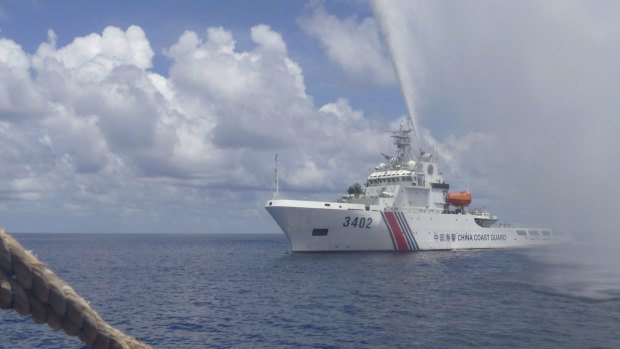 A Chinese Coast Guard boat sprays a water cannon at Filipino fishermen near Scarborough Shoal in the South China Sea.