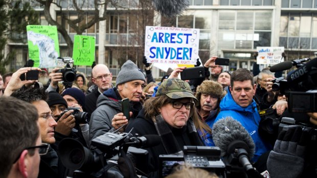 Filmmaker Michael Moore, who was born in Flint, attends a rally outside City Hall, accusing Michigan Governor Rick Snyder of poisoning the city's water.