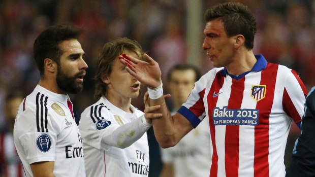 Atletico Madrid's Mario Mandzukic, right, suffers a bad head gash.