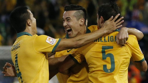 You beauty: Australia's Jason Davidson celebrates with teammates Tim Cahill and Mark Milligan after scoring a goal against UAE during their Asian Cup semi-final at Hunter Stadium.