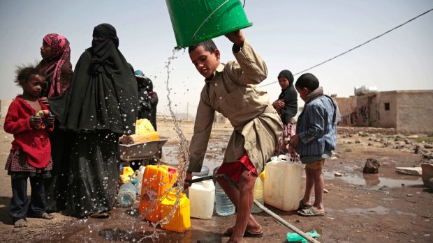 A boy rinses a bucket as he collects water from a well on the outskirts of Sanaa that is reportedly contaminated with cholera bacteria.