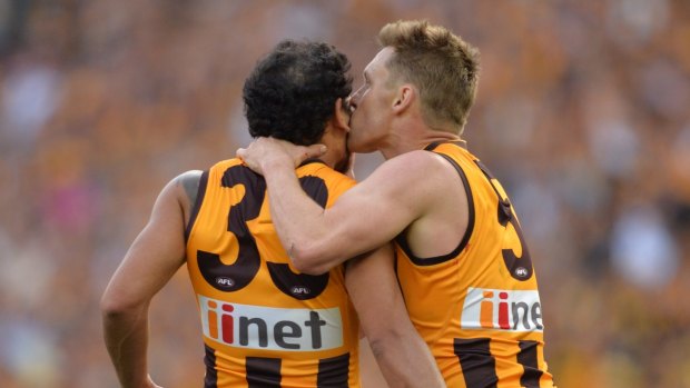 Sealed with a kiss: Cyril Rioli and Sam Mitchell celebrate their win.