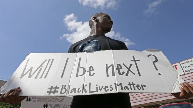 Niamke Ledbetter, of Oak Cliff, Texas, holds a sign at a Black Lives Matter protest in Dallas on Sunday.