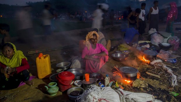 Rohingya Muslims, who crossed over from Myanmar into Bangladesh, prepare a meal in the open at Taiy Khali refugee camp, in Bangladesh.
