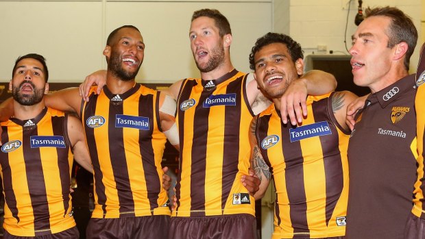 All smiles: Hawthorn players belt out the team song in the rooms