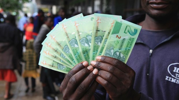 A man holds the new bond notes introduced by the Reserve Bank of Zimbabwe on Monday.