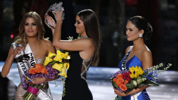 Former Miss Universe Paulina Vega, centre, removes the crown from Miss Colombia Ariadna Gutierrez, left, before giving it to Miss Philippines Pia Alonzo Wurtzbach, right.