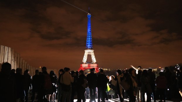 The Eiffel Tower is illuminated in the colours of the French flag.