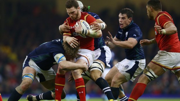 Three's company: George North of Wales is wrapped up by Richie Gray, Blair Cowan and John Hardie.