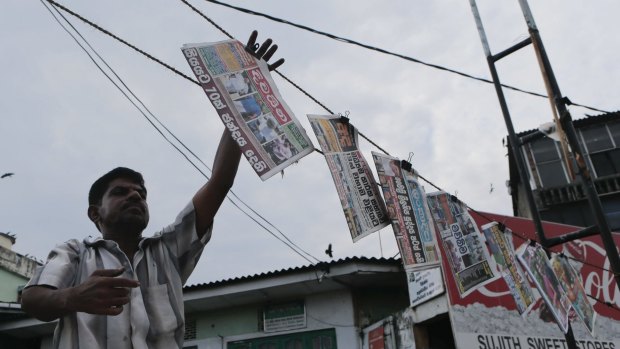 A Sri Lankan vendor hangs a newspaper that says 70 per cent voted a day after voting in parliamentary elections in Colombo.