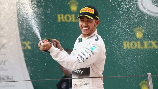 Lewis Hamilton celebrates on the podium after his win.