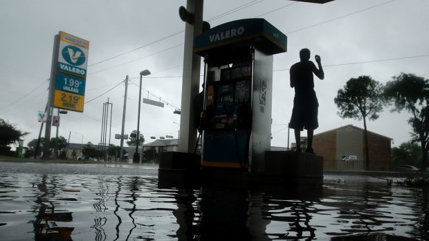 A man watches heavy rain from the relative safety of a flooded petrol station caused by Tropical Storm Harvey in Houston on Sunday.