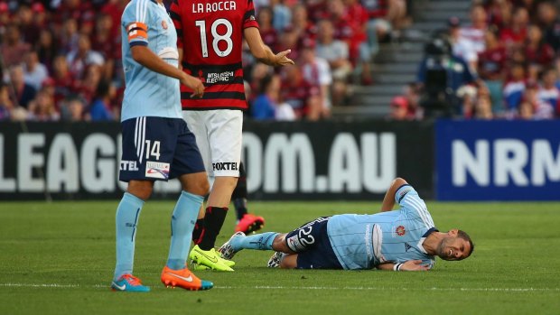Pain for Sydney: Iacopo la Rocca of the Wanderers appeals to the referee as Ali Abbas of Sydney FC lies injured on the ground.