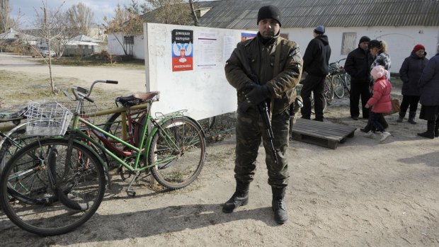 A pro-Russian militant guards a polling station in Novoazovsk, in the eastern Ukrainian Donetsk region on Sunday.