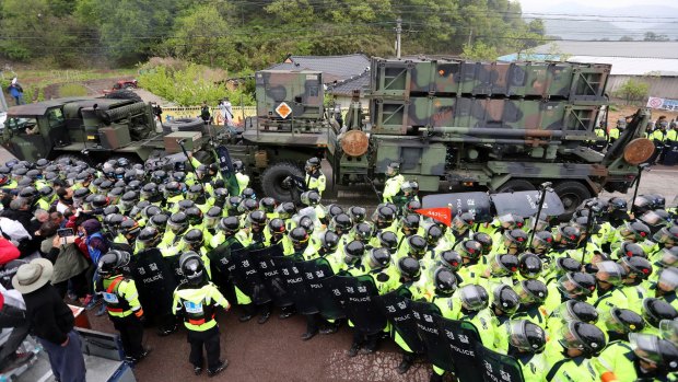 South Korean police protect a US military vehicle from protesters who oppose a plan to deploy the THAAD system against North Korean attack in April 2017.