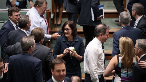 MPs cross the floor during a division at Parliament House.