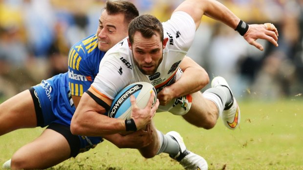 Match-winner: Wests Tigers winger Pat Richards is tackled by Eels centre Ryan Morgan on Monday.