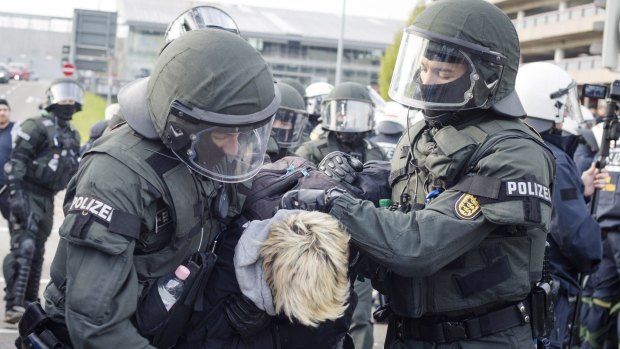 Police detain a leftist demonstrator near the site of the Alternative for Germany party convention.