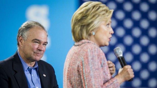 Senator Tim Kaine listens while Hillary Clinton speaks at a campaign event in Annandale, Virginia, on July 14.