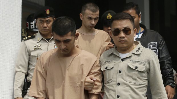 Thai corrections officers escort Yusufu Mieraili, left, and Adem Karadag, rear, from a military court in Bangkok on Tuesday.