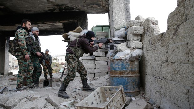 Syrian army soldiers fire their weapons during a battle with insurgents east of Aleppo, Syria. 