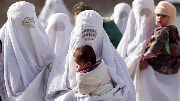 Afghan women with children, refugees from Kunduz province walk to the town of Taloqan.