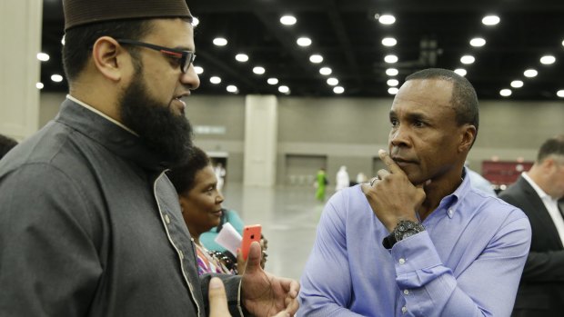 Safih Amed, left speaks with former boxing champion Sugar Ray Leonard before Muhammad Ali's funeral.