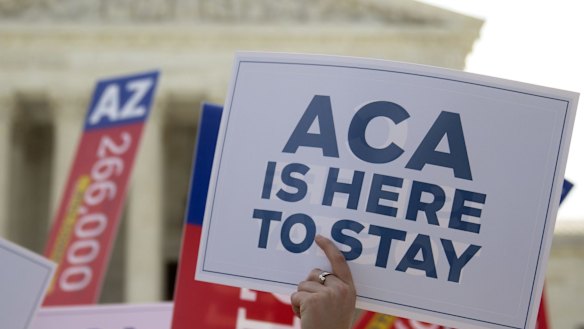 A demonstrator in support of US President Barack Obama's healthcare law, the Affordable Care Act after the US Supreme Court ruled 6-3 to save Obamacare tax subsidies in 2015. 