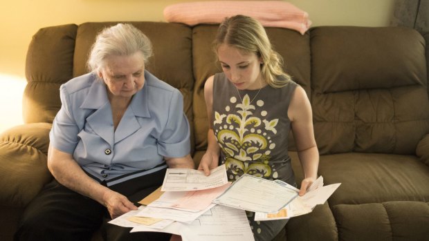 Myrtle Delahuerta, 85, left, goes over her documents at her home with attorney Abbie Kamin. Ms Delahuerta has tried unsuccessfully for two years to obtain a photo ID so she can vote. 