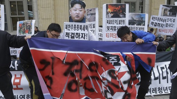 Conservative activists cut a North Korean flag at a rally in Seoul to mark the fifth anniversary of North Korea's attack on Yeonpyeong island.