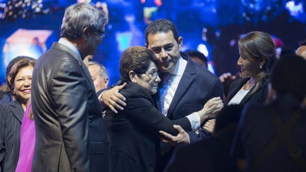 Jimmy Morales, of the National Front of Convergence party, centre, with his mother Celita Cabrera as they celebrate winning the presidential run-off election on Monday.