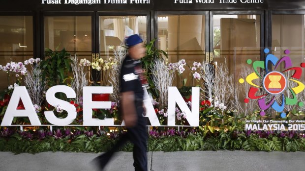 A Malaysian police officer walks past an ASEAN logo during the 48th ASEAN Foreign Minister Meeting in Kuala Lumpur.