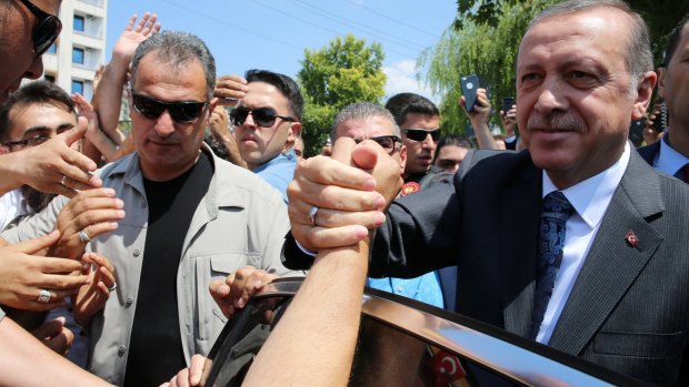 Turkey's President Recep Tayyip Erdogan shakes hands with supporters outside the Osmanli mosque in Ankara on Thursday.