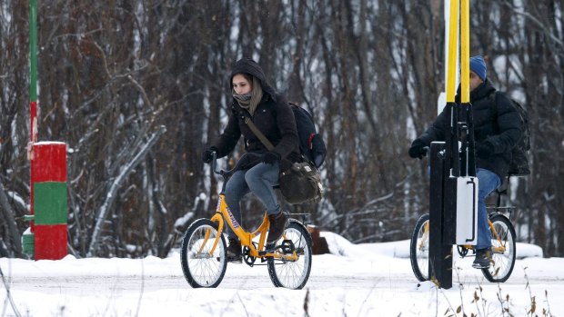 Two refugees use bikes to cross the border between Norway and Russia in Storskog near Kirkenes in Northern Norway, in November 2015. 