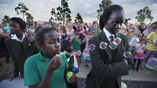 The community of Wyndham Vale blow bubbles during a memorial service for the three victims at Lake Gladman.