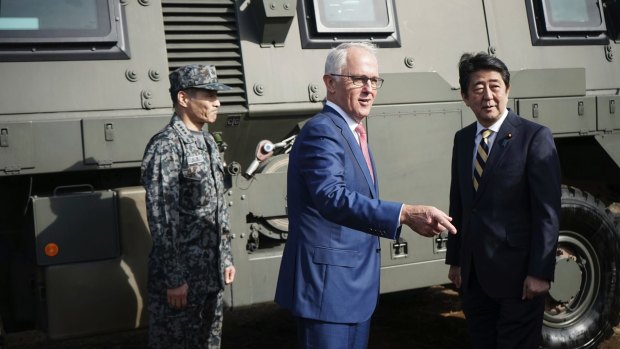 Australian Prime Minister Malcolm Turnbull, centre and Japanese counterpart Shinzo Abe at Narashino Exercise Area east of Tokyo on Thursday.