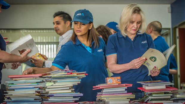 Volunteers sort childrens books at the launch of The Smith Family's 2016 Christmas Appeal.