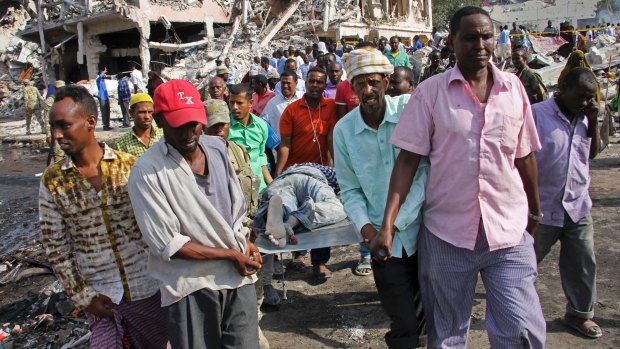 Somalis remove the body of a man killed in Saturday's blast in Mogadishu.