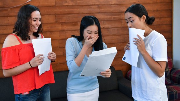 Lauriston Girls' School student Caitlin Louey (middle) opens her International Baccalaureate results, while friends Cassandra Murrell and Isabel Nakonieczny look on. 